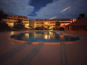 A swimming pool surrounded by buildings with balconies, a clear sky, and a sunset. - Casa Tortuga Sal Apartment 1st Floor With Balcony (Sal)