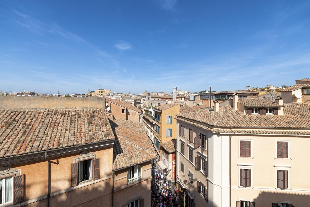 A cityscape with traditional architecture, including terracotta-tiled roofs and a mix of building styles.