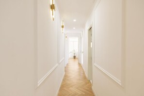 A long, narrow hallway with white walls and a wooden floor, leading to a door at the end. - In the enchanting setting of the Trevi Fountain, in the heart of the historic center of Rome, this splendid apartment has just been renovated, located on the fourth floor with lift. The property is spread over 200 square meters and consists of a large li (roma)