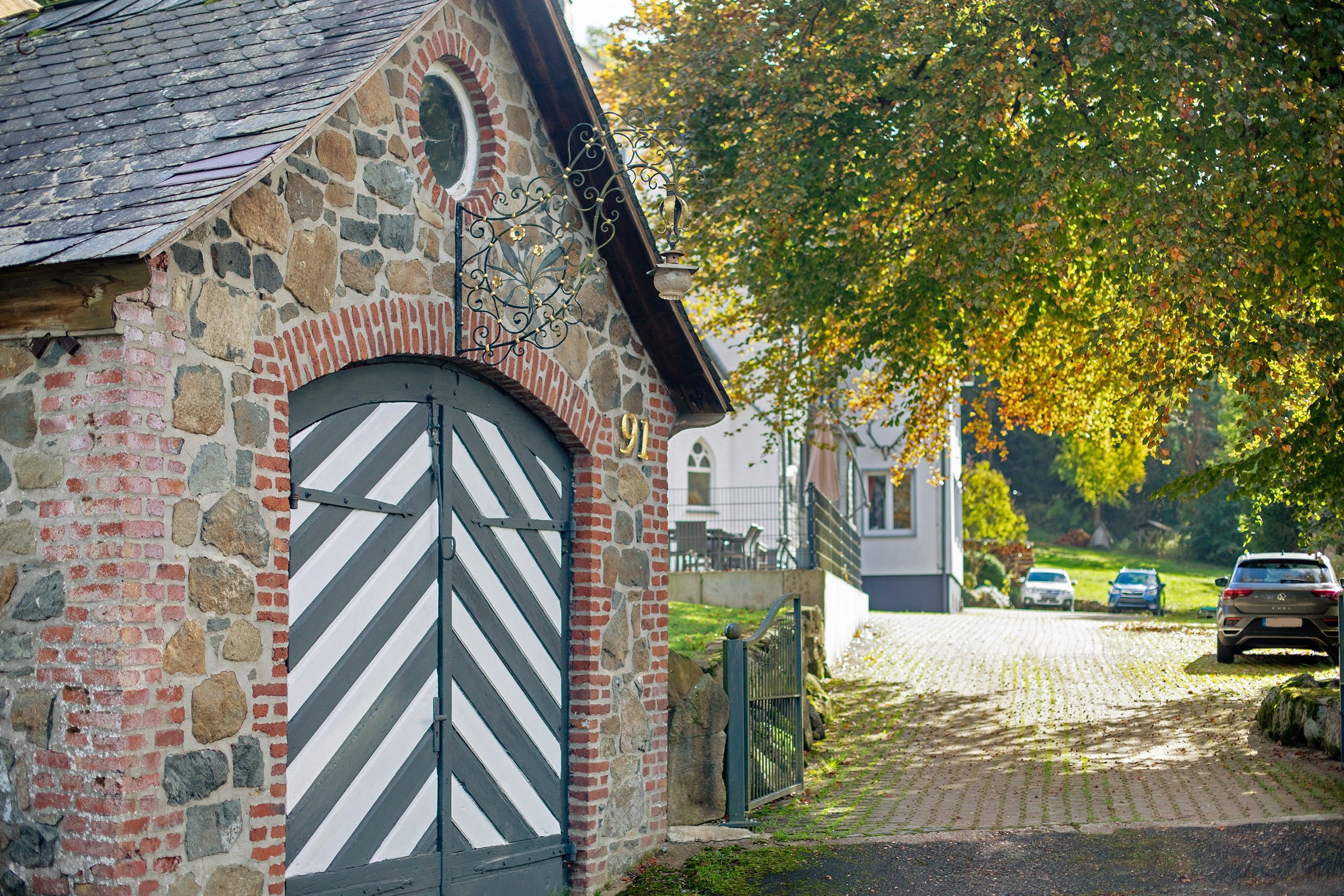 A stone building with a distinctive arched entrance and a metal gate.