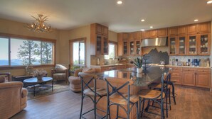 A spacious kitchen with wooden cabinets, a large island, and bar stools. - Mountain Home on 8 Acres - Amazing Views / Outdoor Spaces - 19 Min to DGO (Durango)