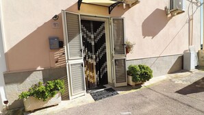 Un bâtiment doté d’une porte, d’un petit jardin et d’un appareil de climatisation.