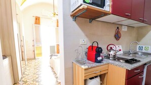 Une petite cuisine équipée d’un four à micro-ondes, d’une bouilloire et d’un grille-pain.