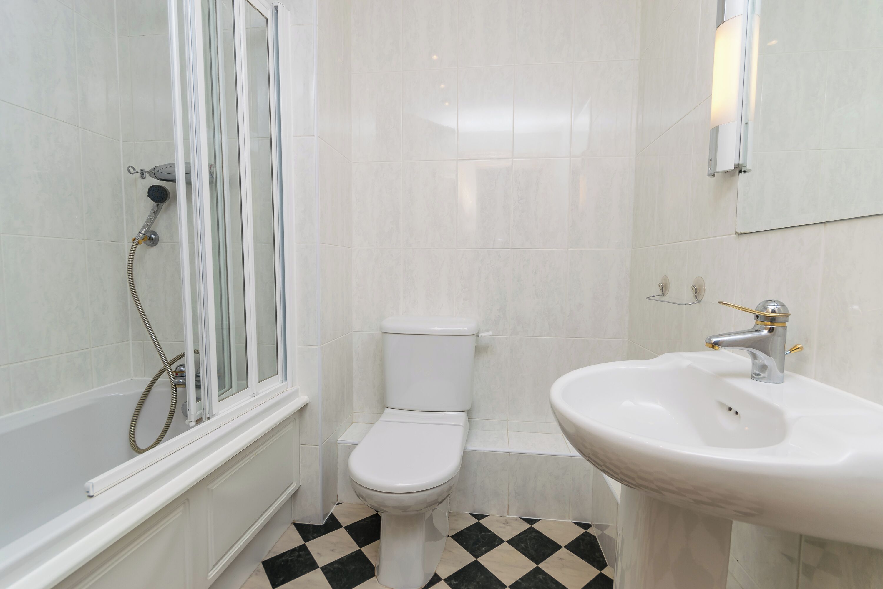 Un baño con ducha, inodoro y lavabo.