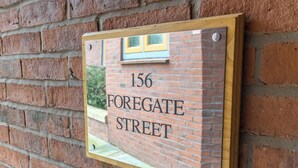 A brick wall with a sign that reads '156 Foregate Street.' - Central Apartment with Parking by Guestz (Chester)