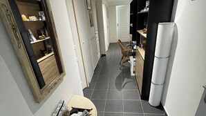 Un pasillo con comedor, espejo y refrigerador.