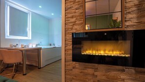 Eine moderne Küche mit einer Wand aus Stein, einem eingebauten Kamin und einem großen Fenster.