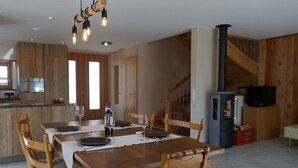 Ein Essbereich mit Holztisch, Stühlen und einer hängenden Lampe.