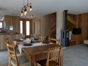 Ein Essbereich mit Holztisch, Stühlen und einer hängenden Lampe.