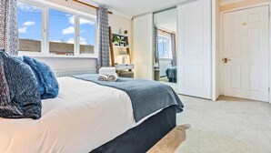 A bedroom with a bed, a window, a wardrobe, and a mirror. - Cozy Family & Contractor Home, 3X FREE Parking by Redwood Stays (Hampshire)