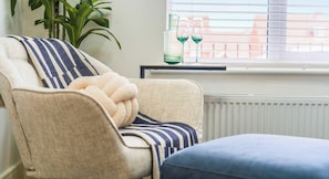A chair with a striped cushion, a small table with two glasses, and a radiator. - NEW Farnborough Air Show House, X2 FREE Parking (Aldershot)
