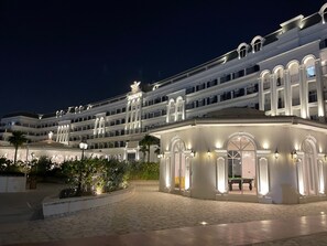 Ein mehrstöckiges Hotel mit Innenhof, großen Fenstern und einer markanten Eingangspartei.