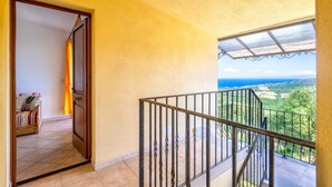 Un balcon doté d’une rambarde en métal et offrant une vue sur un paysage.