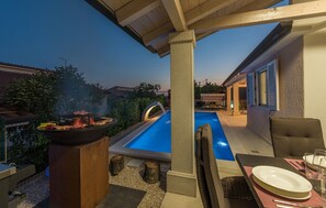 An outdoor pool area with a barbecue grill, seating, and a covered patio. - Elegant Villa Delijamo with private Pool near Poreč – Peaceful Istrian Escape (Zbandaj)