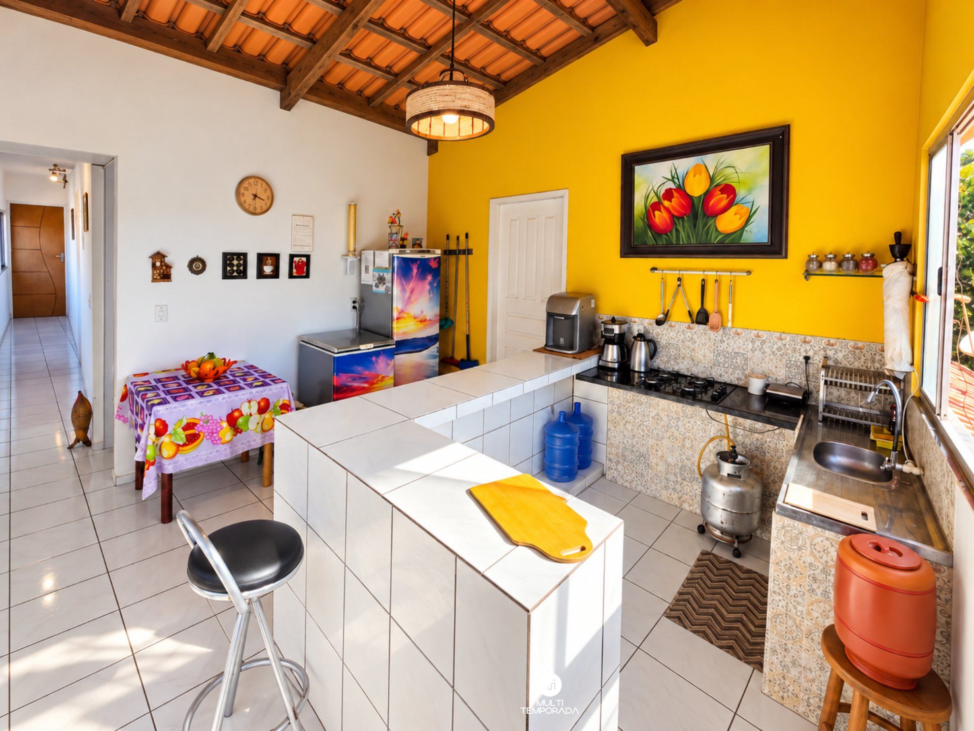 A compact kitchen with a dining area, a coffee machine, and a refrigerator.