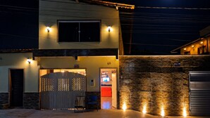 A two-story building with a balcony and a lit entrance. - Casa Vilar Rio Lençois Maranhenses (Barreirinhas)