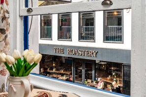 A restaurant named 'The Roastery' with outdoor seating visible through the windows. - Simply Boho | By My Getaways (Brighton)