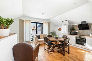 Eine moderne Küche mit Essbereich, Holzboden und Blick durch das Fenster.