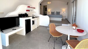 Quarto de hotel compacto com cozinha compacta, área de refeições e cama com vista.