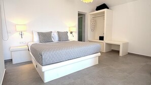 Quarto com cama, abajures, um banco, closet espaçoso e luminária pendente.