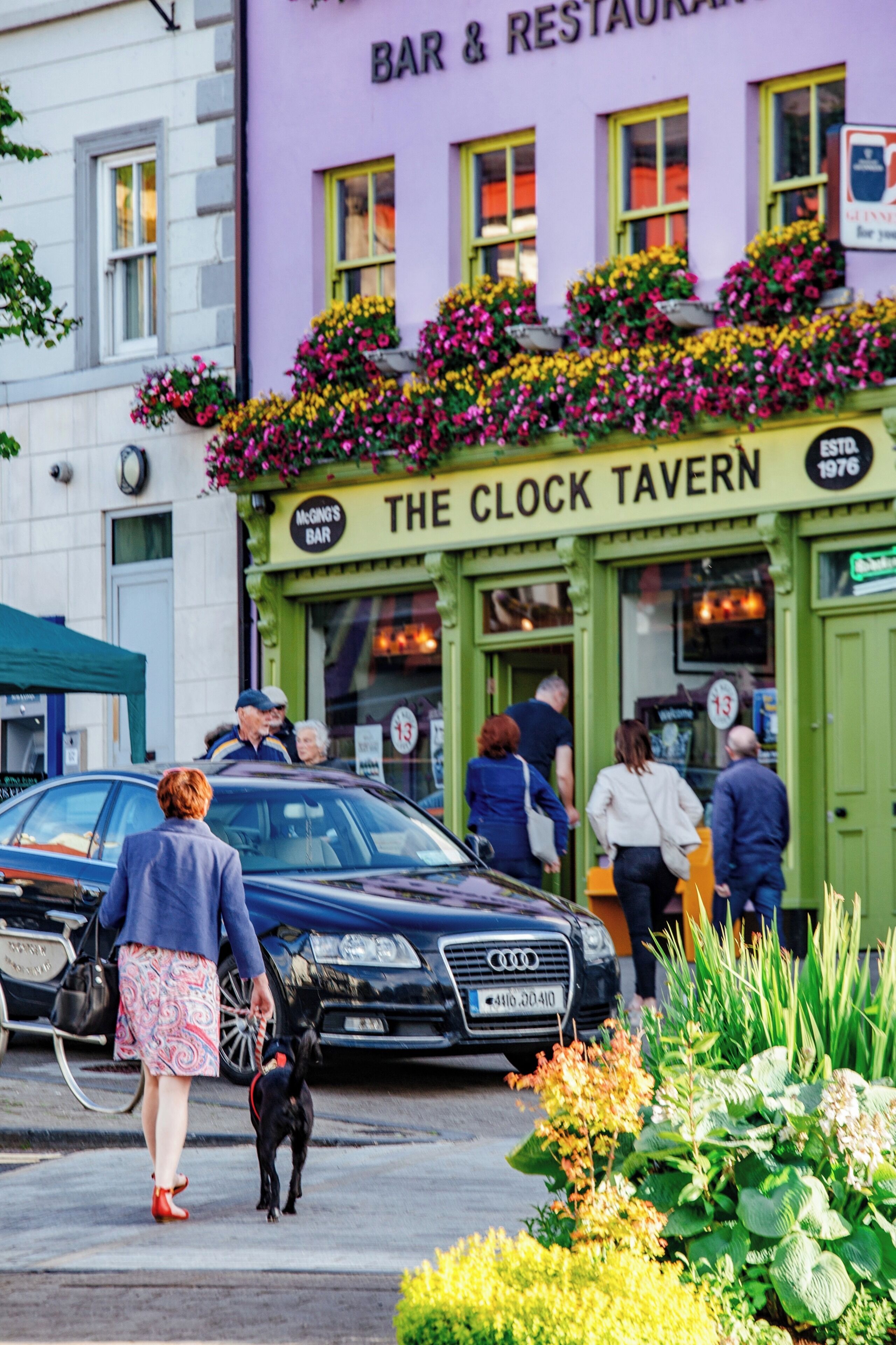 Un bâtiment sur lequel on peut lire l’inscription « THE CLOCK TAVERN » et qui est doté d’une marquise verte.