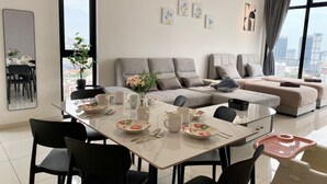 Un salon moderne comprenant un canapé, une table à manger, des chaises et des œuvres d’art accrochées aux murs.