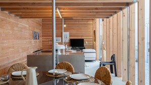 A wooden interior with a dining area, a TV, and a sofa. - Cabane Cala – Heart of Arcachon & Beaches Within Walking Distance (Arcachon)