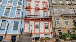 Une rangée d’immeubles à étages, avec un panneau indiquant une durée maximale de stationnement de trois heures.