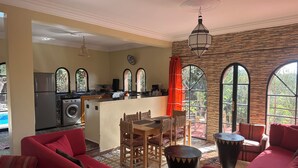Un'ampia zona giorno con divani rossi, un tavolo da pranzo e una cucina con un'isola grande.