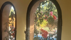 Una cucina con lavello, due finestre ad arco e vista su piscina e giardino.