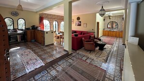 Un'ampia zona giorno con cucina, sala da pranzo e un divano rosso.