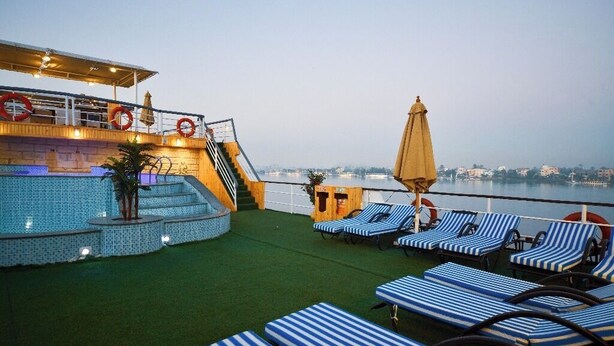 A rooftop deck with a pool, lounge chairs, and a bar area. - MS Nile Treasure Cruise (Luxor)