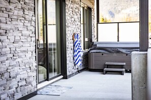 Ein Wellnessbereich mit Steinwand, Whirlpool und Sitzbank.