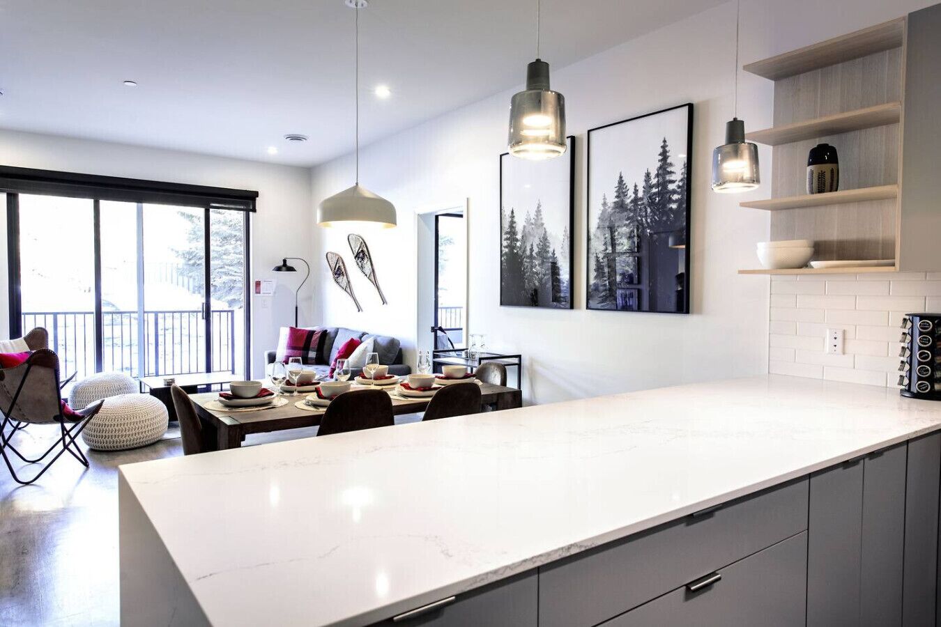 A modern kitchen with a large island, pendant lights, and framed artwork on the wall.
