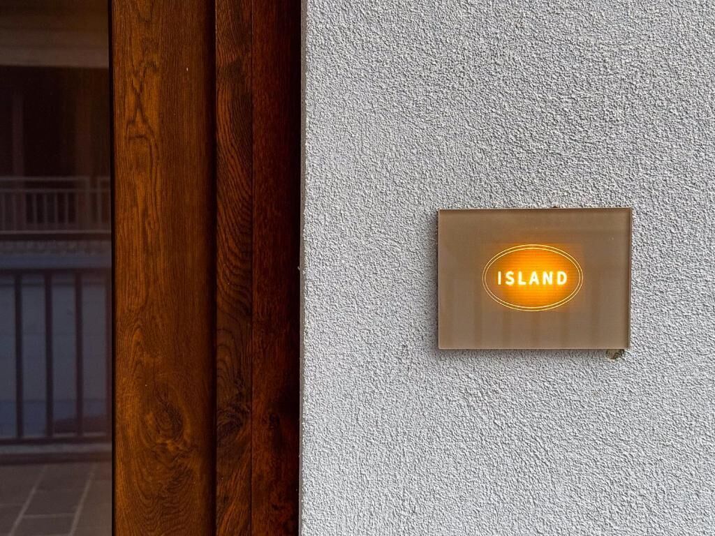 Une enseigne portant le mot « ÎLE » sur un mur à texture.