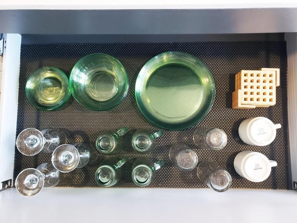 Eine Schublade mit unterschiedlichem Glas und einem Holzklotz.