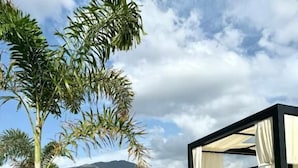 Un espacio al aire libre moderno con mobiliario minimalista y una vista despejada del paisaje circundante.