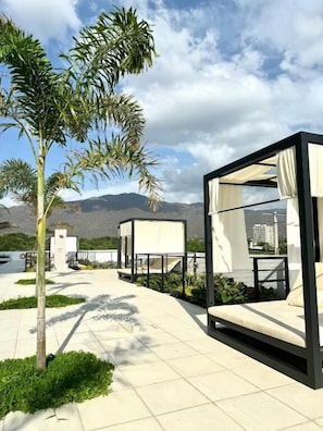 Un espacio al aire libre moderno con mobiliario minimalista y una vista despejada del paisaje circundante.