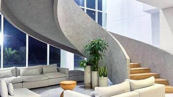 Un interior moderno con una escalera curva, un sofá y una mesa de centro.