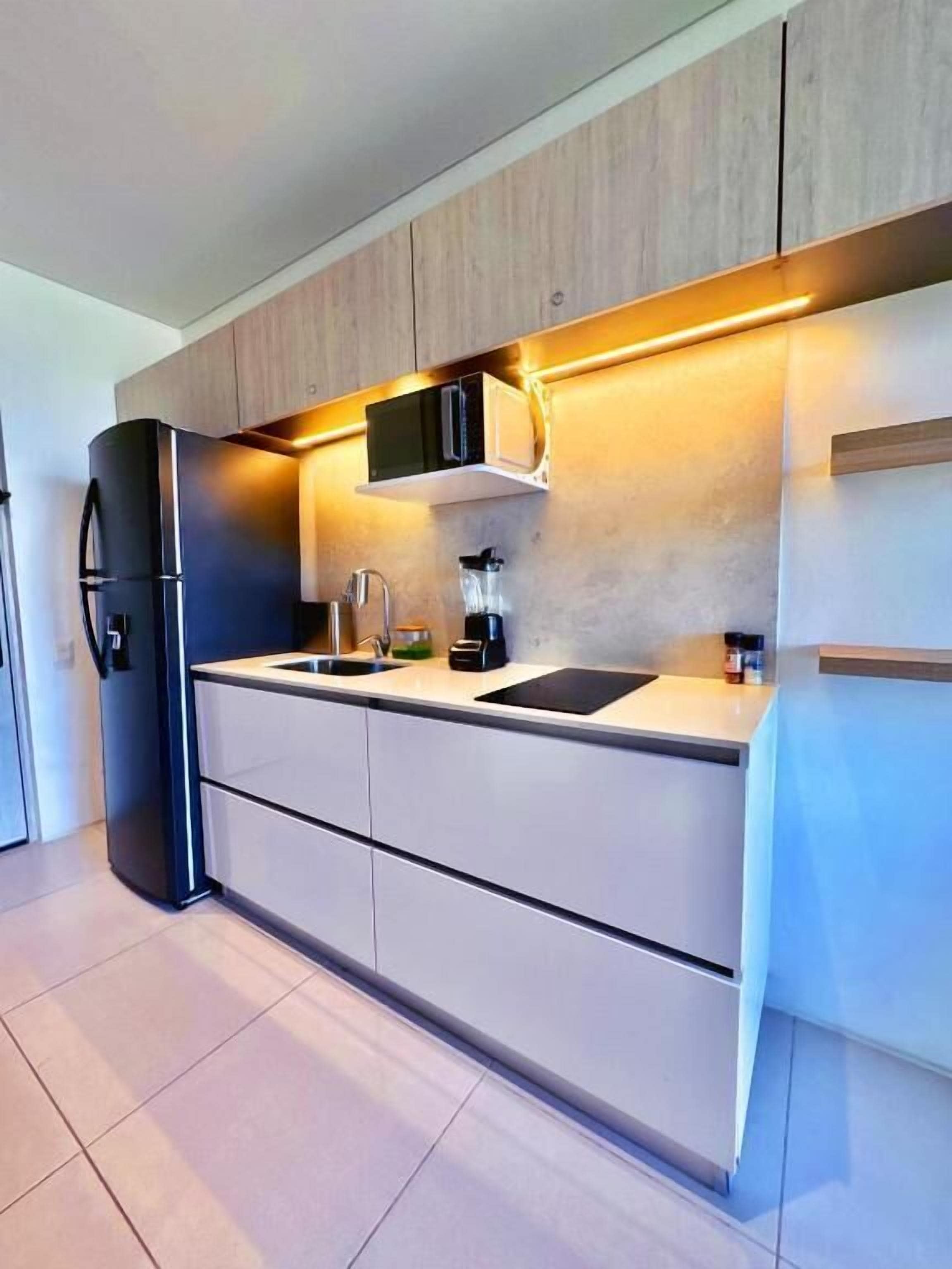 A modern kitchen with built-in appliances, a countertop, and a backsplash.
