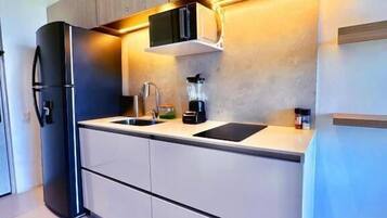 A modern kitchen with built-in appliances, a countertop, and a backsplash.