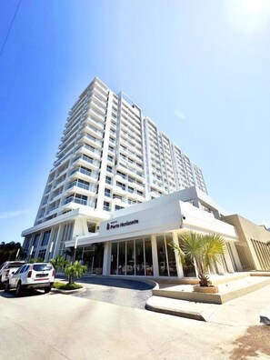 Um hotel moderno e imponente com um design elegante, destacando uma entrada notável e uma placa com o nome visível.