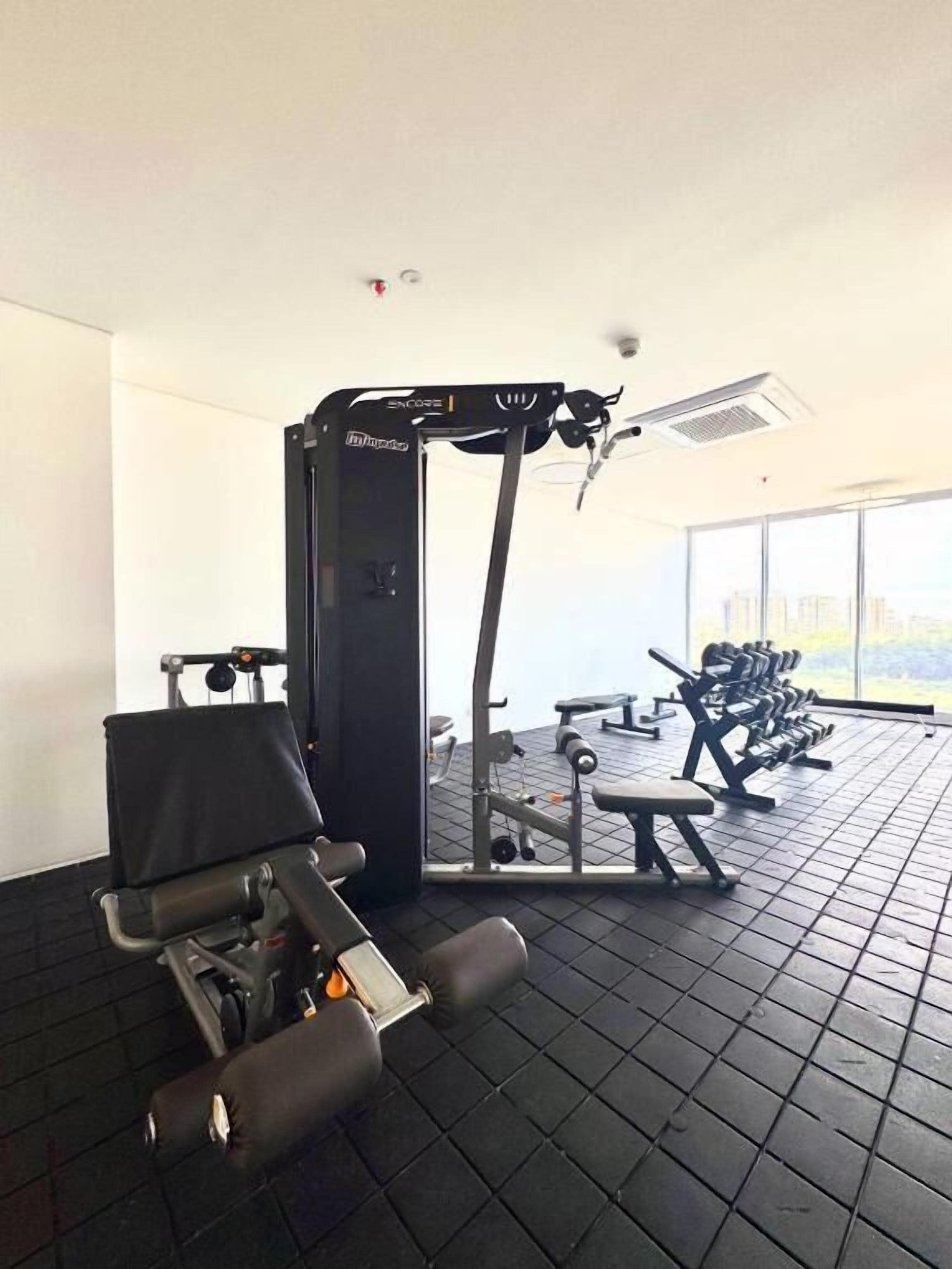 A gym with a squat rack, bench press, and weight machines.