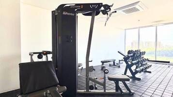 A gym with a squat rack, bench press, and weight machines.