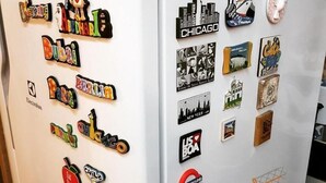 A refrigerator with various magnets, including city names and images. - Hostel Casa de Avany (Cachoeira)