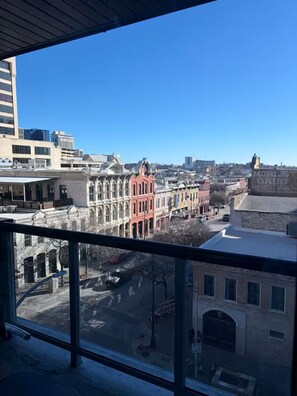 Stadtansicht mit historischen Gebäuden, blauem Himmel und Blick von einem Balkon.