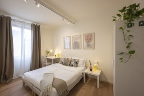 A bedroom with a bed, bedside tables, a desk, and a chair. - Apartments Florence - San Marco Design Apartment (Firenze)