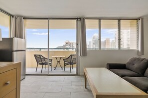 Ein modernes Apartment mit Balkon, Esstisch, Sofa und Küchenzeile.