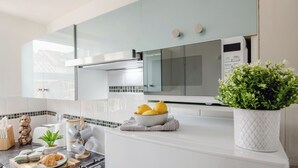 Une cuisine moderne équipée d’une cuisinière à gaz, d’un four à micro-ondes et d’un grille-pain.