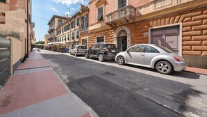A street with parked cars, a sidewalk, and buildings with balconies. - Bed and Breakfast 'Sentieri' with Wi-Fi and Air Conditioning (Levanto)